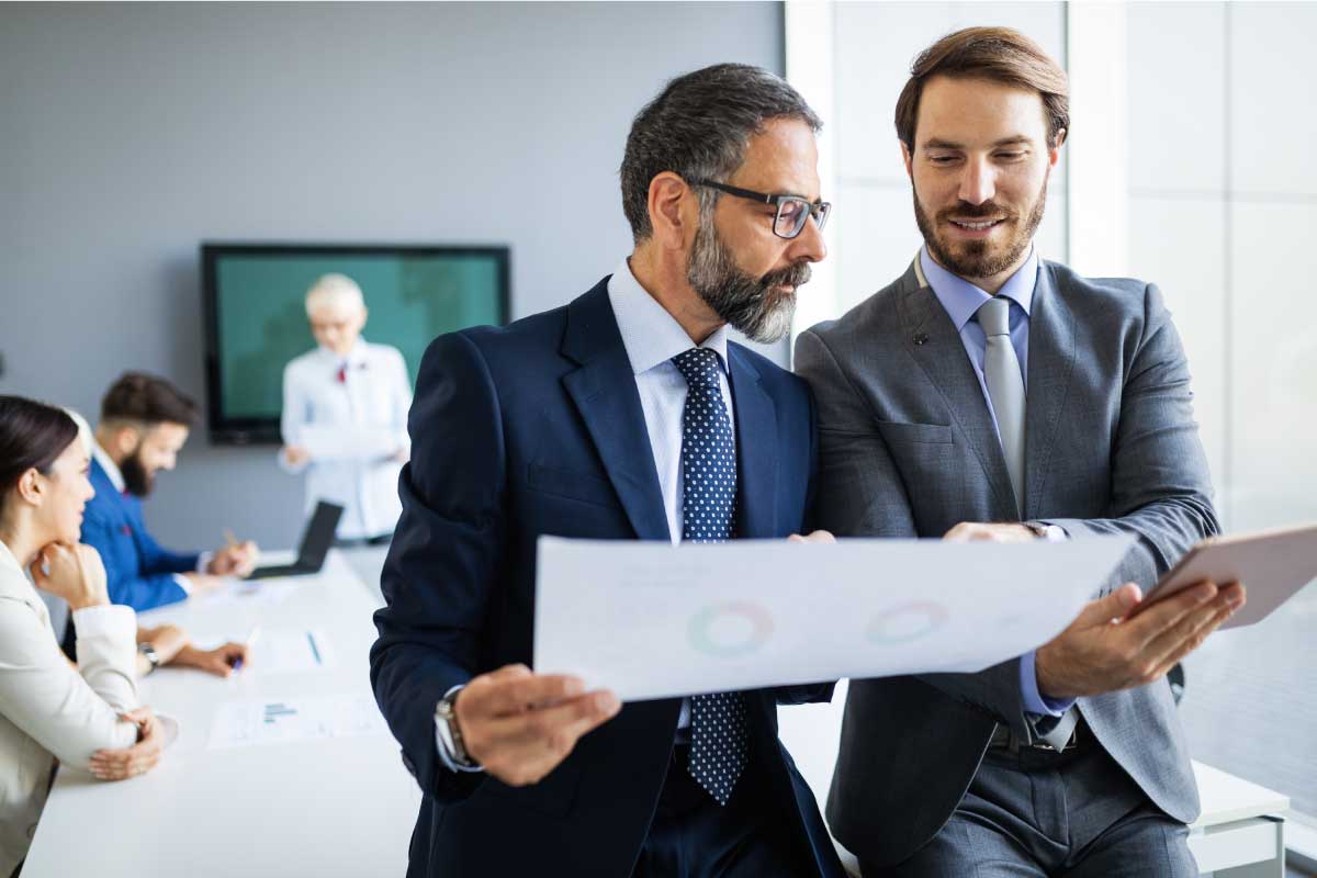 Dos hombres de negocios analizando información en papel