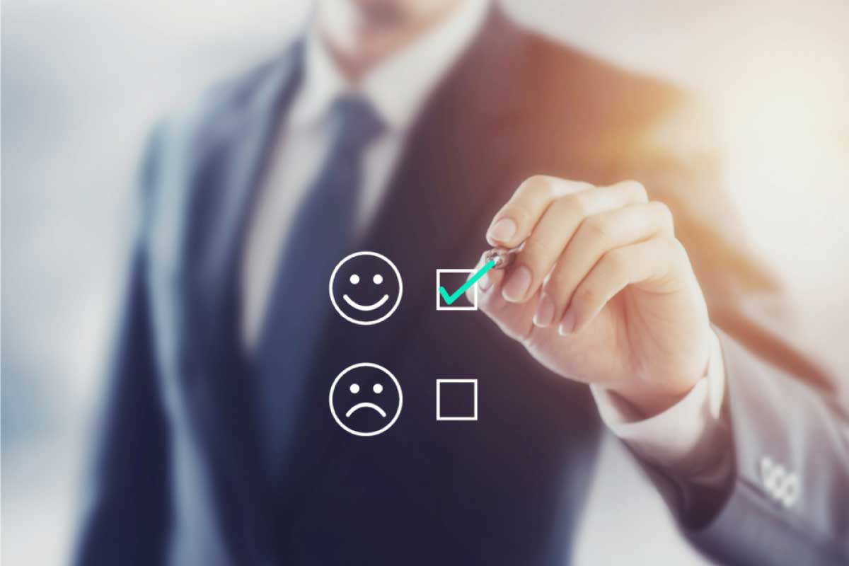 Hombre de negocios poniendo una marca sobre la opción de feliz, representada con un emoji