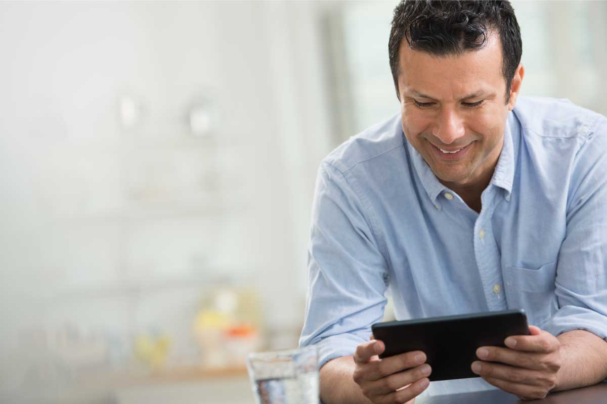 Hombre de negocios sosteniendo una tablet y sonriendo