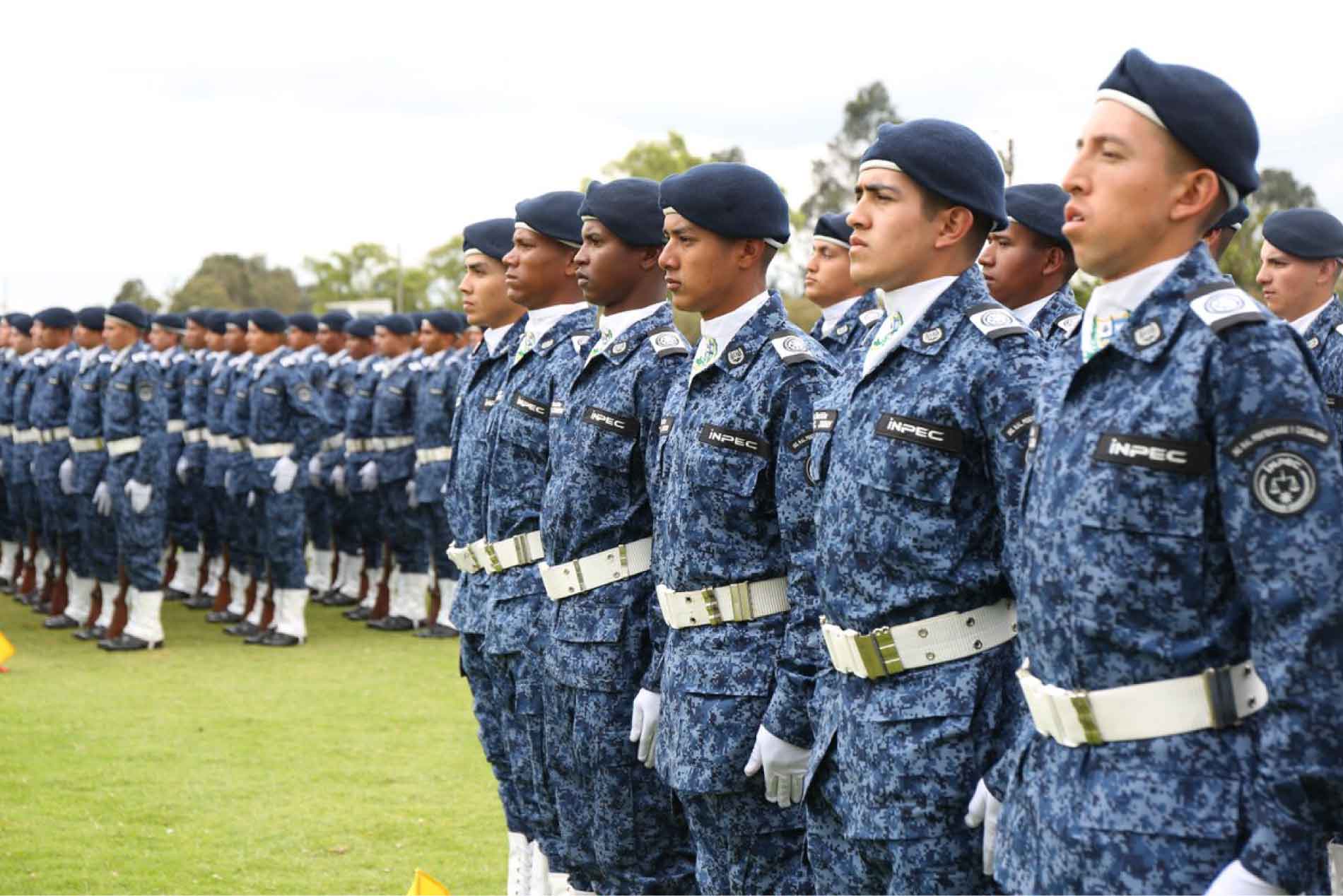 Grupo de jóvenes con uniforme del INPEC, en ceremonia militar.