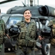 3 soldados de la Fuerza Aérea al frente de un helicóptero, sonriendo a la cámara.