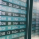Acercamiento de un tablero de vuelos de un aeropuerto, mostrando varios números de vuelos y sus horas de salida.