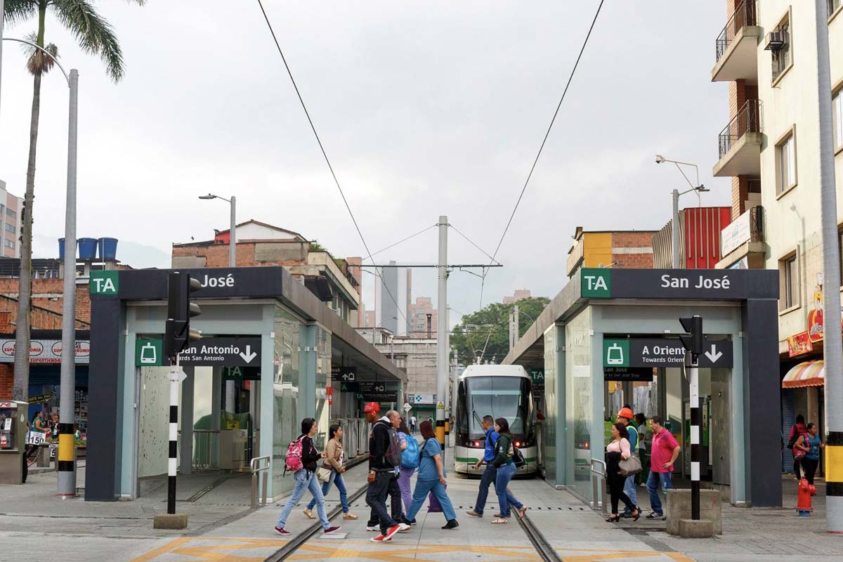 Grupo de personas cruzando al frente del sistema de transporte de Medellín