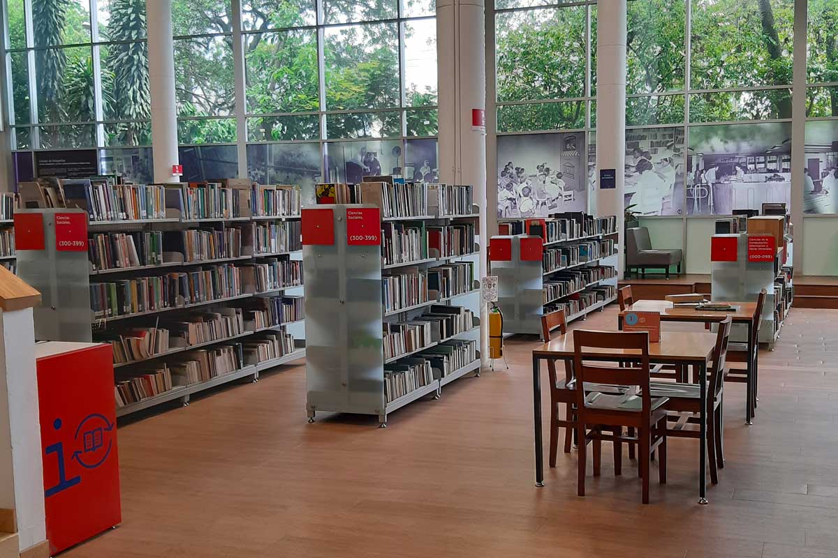 Sala de la Biblioteca Pública Piloto de Medellín, con estanterías de libros y mesas