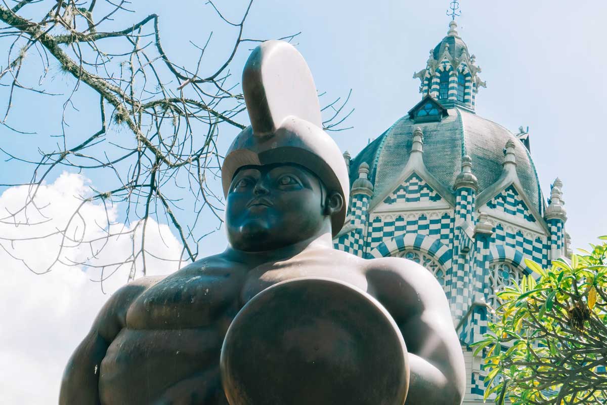 Palacio de la Cultura de Medellín como fondo y al frente una estatua del Maestro Botero